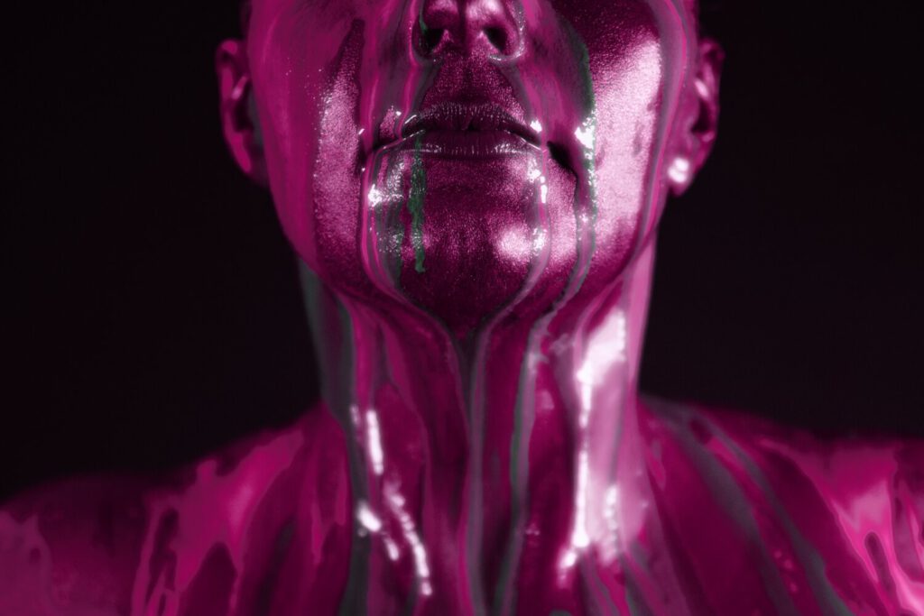 Bei einer Bodyart-Performance stylt Künstler Jörg Düsterwald ein Aktmodell mit kupferfarbener Grundierung und besprenkelt die Person anschließend experimentell mit viel flüssiger, bunter Farbe.